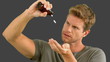 Man pouring out pills on grey screen