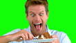 Attractive man about to eat a cake on green screen