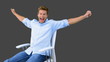 Man on swivel chair raising arms to show his succes