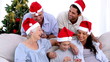 Family watching little boy open christmas present