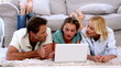 Video: Parents and daughter happily using laptop on floor Parents and daughter happily using laptop on floor