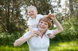 smiling mother holding a child on his shoulders