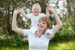 smiling mother holding a child on his shoulders