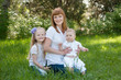 Happy beautiful family sitting on a green grass