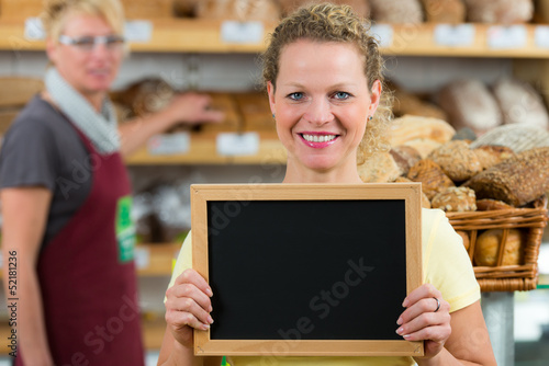 Photo: bäckereifachverkäuferin mit hinweistafel bäckereifachverkäuferin mit hinweistafel