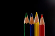 Four primary color pencils before black background