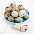Saucer full of raw quail eggs, close-up, studio shot