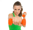 Fitness young woman making exercise with dumbbells