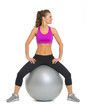 Smiling fitness woman on fitness ball looking on copy space