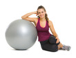 Happy fitness young woman sitting near fitness ball