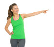 Photo: Happy fitness young woman pointing on copy space Happy fitness young woman pointing on copy space