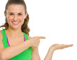 Happy fitness young woman presenting something on empty palm