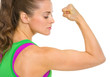 Fitness young woman showing biceps
