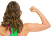 Fitness woman showing biceps . rear view