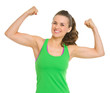 Happy fitness young woman showing biceps