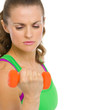 Concentrated fitness young woman making exercise with dumbbells