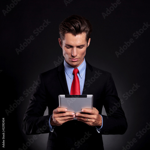 Photo: business man looks at tablet business man looks at tablet