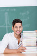 lächelnder student mit einem stapel bücher