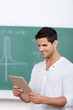 lächelnder student schaut auf tablet