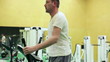 Video: Young man exercising on elliptical cross trainer in gym Young man exercising on elliptical cross trainer in gym