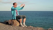 Video: Young happy man taking photo with cellphone by the sea Young happy man taking photo with cellphone by the sea