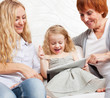 Family wiht tablet computer at sofa