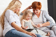 Family wiht tablet computer at sofa
