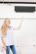 Female holding a remote control air conditioner