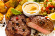 Grilled steak, baked potatoes and vegetables