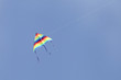 A colorful triangular kite flying in the sky