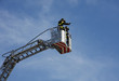 firefighters in the basket of the scale of the fire truck when s