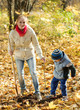  woman with  son planting  tree in autumn