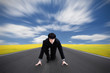 Young asian businessman kneeling as if about to start a race