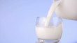 Milk being poured from plastic bottle to glass
