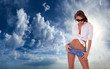 Foto: woman in jeans shorts standing on blue cloudy sky woman in jeans shorts standing on blue cloudy sky