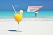 Glass of orange juice on the sandy beach of Exuma, Bahamas