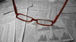Glasses falling over sheets of paper showing graphs and data