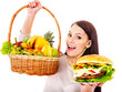 Woman choosing between fruit and hamburger.