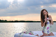 The girl woke up in a bed on water and drink cup of coffee.