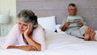 Woman worried about something while her husband is reading newspapers