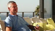 Man drinking a glass of wine while sunbathing