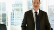 Happy businessman standing by window