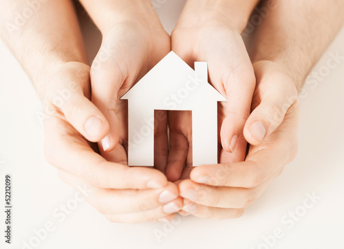 Photo: woman and hands with paper house woman and hands with paper house