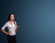 Young woman standing and typing on her phone with copy space