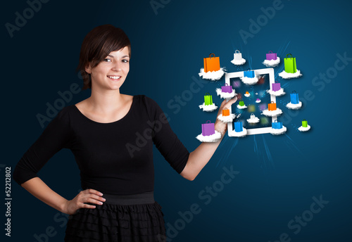 Photo: woman holding modern tablet with colorful shopping bags on cloud woman holding modern tablet with colorful shopping bags on cloud
