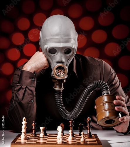 Photo: mann mit gasmaske beim schachspielen 3 mann mit gasmaske beim schachspielen 3