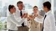 Cheerful business team celebrating with champagne 