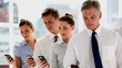 Business people standing in line with their smartphones