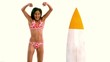Smiling woman jumping next to her surfboard
