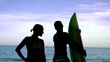 Surfer kissing his girlfriend on the beach and running to the sea